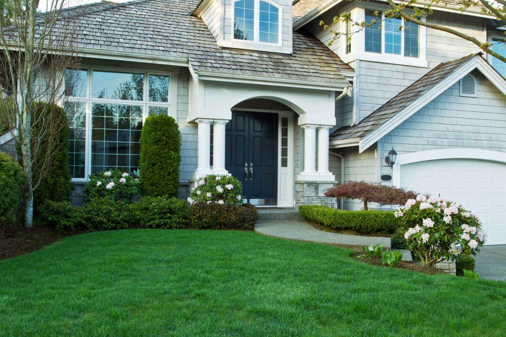Residential front yard with trimmed shrubs and healthy lawn care in Indiana