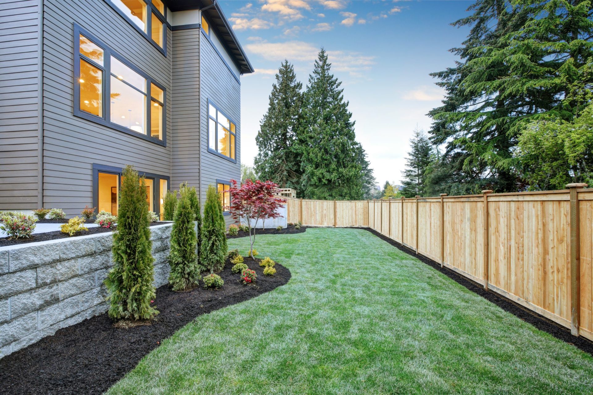 Backyard lawn with fresh mulch and turf treated by lawn care professionals in Indiana